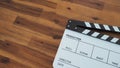 Clapper board or movie slate use in video production, film and cinema industry. It`s white color on wood background Royalty Free Stock Photo