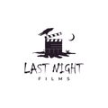 Clapperboard on cracked ground at night and crow illustration logo. Horror movie logo design inspiration