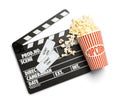 Clapperboard, popcorn and tickets on background, top view. Cinema snack