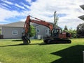 Claresholm, Alberta - June 16th, 2017: A Hitachi excavator sitting on the front lawn of an empty lot ready to begin digging to bu