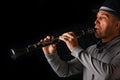 Clarinet in the hands of a man on a black background Royalty Free Stock Photo