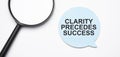 Clarity precedes success speech bubble and black magnifier isolated on the yellow background