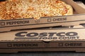 Closeup flat lay top view image of a carton box of delicious made to order COSTCO cheese pizza.