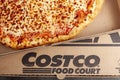 Closeup flat lay top view image of a carton box of delicious made to order COSTCO cheese pizza.