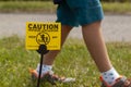 A yellow yard sign warning kids and pets of the recent pesticide spraying