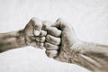 Clash of two fists on toned background. Royalty Free Stock Photo