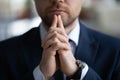 Clasped hands of business leader touching chin in deep thoughts Royalty Free Stock Photo