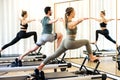 Class in a gym doing pilates standing lunges Royalty Free Stock Photo