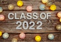 Class of 2022 on paper card with LED cotton balls top view on wooden background
