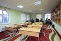 Class-room of the medrese: school desks, shelves with books and Muslim boys standing