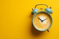 Classic alarm clock with coffee instead of a clock face isolated on a yellow background with copy space. Coffee break, morning Royalty Free Stock Photo