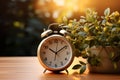 Classic alarm clock and potted houseplant grace wooden tabletop