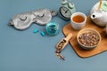 Classic alarm clock, sleeping mask, tea pot on blue pastel background. Minimal concept of rest, quality of sleep, good