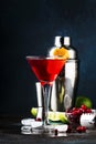 Classic alcoholic cocktail cosmopolitan with vodka, liqueur, cranberry juice, lime, ice and orange zest, dark bar counter Royalty Free Stock Photo