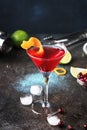 Classic alcoholic cocktail cosmopolitan with vodka, liqueur, cranberry juice, lime, ice and orange zest, dark bar counter Royalty Free Stock Photo