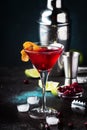 Classic alcoholic cocktail cosmopolitan with vodka, liqueur, cranberry juice, lime, ice and orange zest, dark bar counter Royalty Free Stock Photo