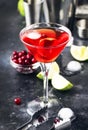 Classic alcoholic cocktail cosmopolitan with vodka, liqueur, cranberry juice, lime, ice and orange zest, gray bar counter Royalty Free Stock Photo