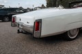 Classic american Cadillac car in store parking. Rear detail of white luxury retro vintage automobile headlight Royalty Free Stock Photo