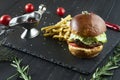 Classic American fast food - juicy burger with beef cutlet, tomatoes and cheddar cheese with a side dish of salad and french fries Royalty Free Stock Photo