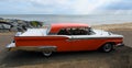 Classic American Ford Galaxie automobile parked on seafront promenade beach and sea in background. Royalty Free Stock Photo