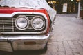 Classic American retro car under car case on the street. Bumper and headlight of red vintage car. Royalty Free Stock Photo