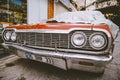 Classic American retro car under car case on the street. Bumper and headlight of red vintage car. Turkey, Cappadocia