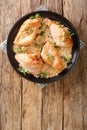 Classic Amish baked chicken breast with garlic and paprika close-up in a plate. vertical top view