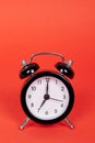 Classic analog clock with bells. Isolated on red background. Copy space