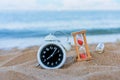 Classic analog clocks and Message or letter in bottle with hourglass in sand on the tropical beach, Time concept