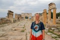 A classic antique Greek theater in Pamukkale, Denizli, Turkey and a white young woman in a hippie dress Royalty Free Stock Photo