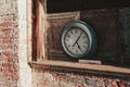 Classic antique pendulum clock mounted on a brick wall in an aged building Royalty Free Stock Photo