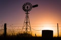 Classic Australian windmill on farmland silhouetted at sunset Royalty Free Stock Photo