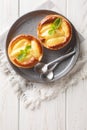 Classic baked Apple tartlet with custard and mint closeup in a plate. Vertical top view