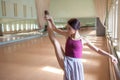 Classic ballet dancer posing at barre on rehearsal Royalty Free Stock Photo