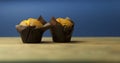 Classic banana nut muffins in black paper wrapper on wooden table