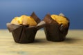 Classic banana nut muffins in black paper wrapper on wooden table