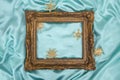 Classic baroque golden brown frame on turquoise blue satin fabric with christmas straw decorations