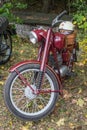 Classic Polish red motorbike WFM parked under autumn tree