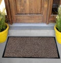 Classic Beige black grey welcome door mat with black border outside home with yellow flowers and leaves Royalty Free Stock Photo