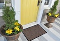 Classic Beige black grey welcome door mat with black border outside home with yellow flowers and leaves Royalty Free Stock Photo