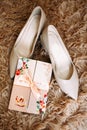 Classic beige bridal shoes on a shaggy rug. Nearby lies an invitation greeting card Royalty Free Stock Photo