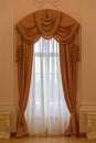 Classic beige curtain hanging on a window Royalty Free Stock Photo