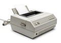 Vintage dot matrix printer with paper feed and power cable attached on a white background Royalty Free Stock Photo