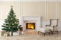 Classic beige interior with christmas tree, fireplace, lounge armchair