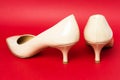 Classic beige patent leather shoes  with kitten heels on red background, back view Royalty Free Stock Photo