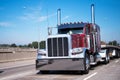 Classic big rig semi truck in dark red and flat bed semi trailer Royalty Free Stock Photo