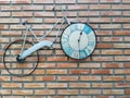 Classic bike parked by brick wall, with clock in wheel