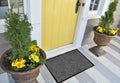 Classic black grey welcome door mat with black border outside home with yellow flowers and leaves Royalty Free Stock Photo