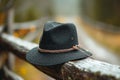 Classic black hat gracefully placed on a weathered wooden fence Royalty Free Stock Photo