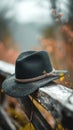 Classic black hat gracefully placed on a weathered wooden fence Royalty Free Stock Photo